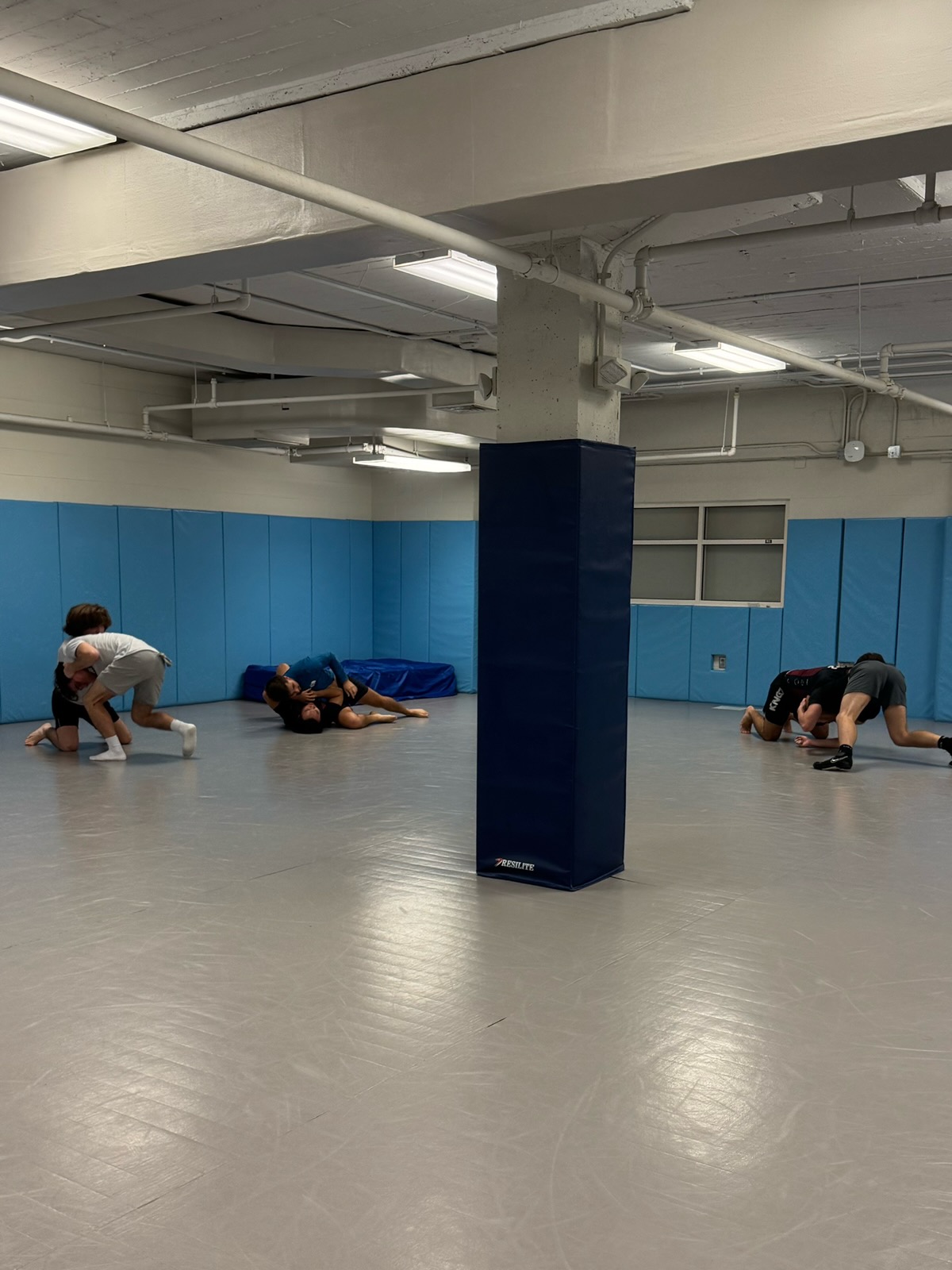 UNC club wrestlers drilling takedowns in the practice room.