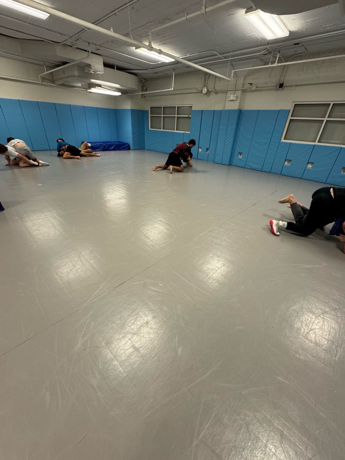 UNC club wrestlers practicing takedowns in the practice room.